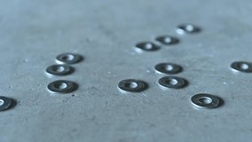 The 4K footage of the screws dropping on the cement floor. the concept of construction, mechanics, industrial and technology.