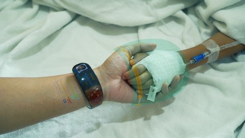 The doctor holding hand with a sick child to diagnose and treat with technological digital holographic. Medical concept of the future high tech hospital. Futuristic Theme.