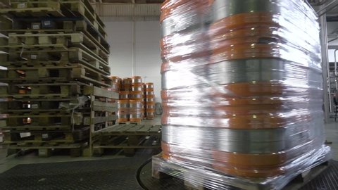 beer kegs wrapped in plastic wrap before transportation. beer factory. apparatus for wrapping keg.