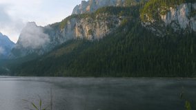 Gosauseen Lake in Austria Alp Mountain, movement fog mist over lake with mountain and morning light background