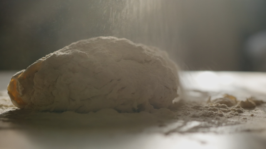 Female hands kneading dough in flour on the table, slow motion, sunlight from the window illuminates the scene. Royalty-Free Stock Footage #1041351103