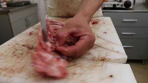 Butcher man hand cutting raw meat with knife. HD1080p.