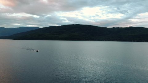 
Aerial Drone Shot of Wakeboard Boat Going Across Wide open Lake At Sunset in Shuswap Lake British Columbia Okanogan