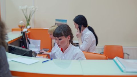 Female at hospital reception. Woman working at the clinic reception desk