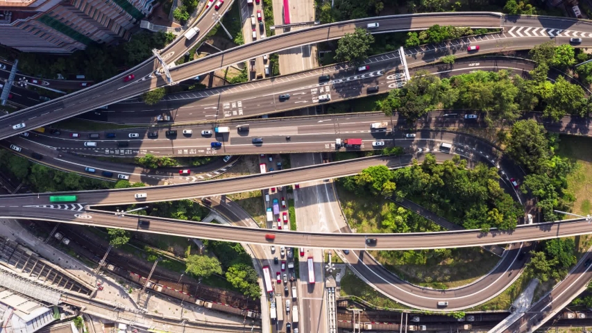 Top down view of a traffic time lapse in a busy highway intersection with railroad tracks in the crowded Kowloon district in Hong Kong, with a zoom out effect. | Shutterstock HD Video #1041378493