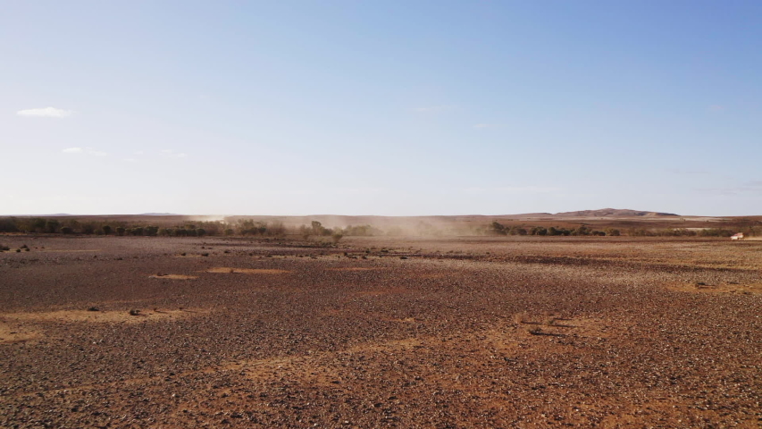 Car driving through dusty desert | Shutterstock HD Video #1041378760
