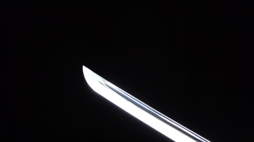 Dramatic studio shot of man holding samurai sword. Close up