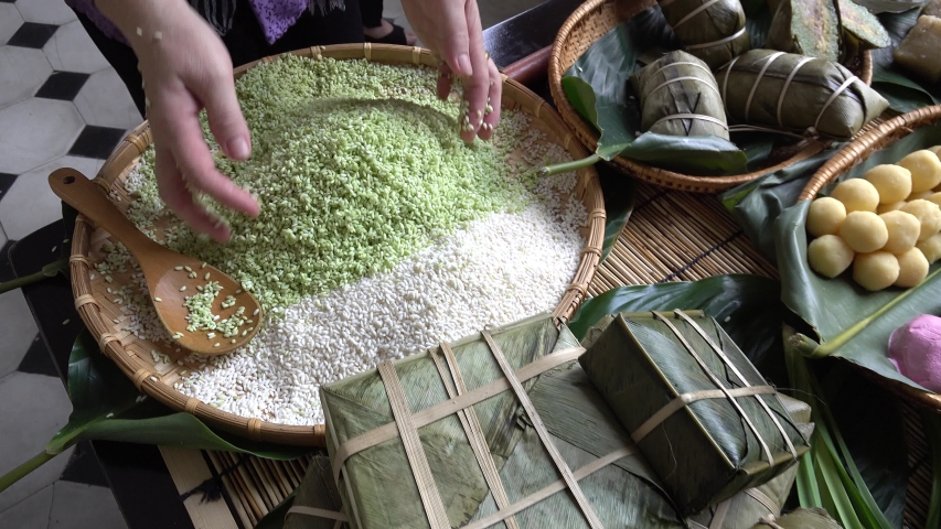 Vietnam - 2019: Material including Sticky rice, pork, been, green leaf for Vietnamese food, banh chung, banh tet are traditional eating on Tet holiday, wrap in green leaf. Vietnamese traditional cake. Royalty-Free Stock Footage #1041381880
