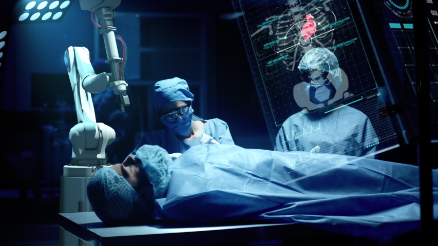 Team of surgeons perform a delicate operation using medical surgical robot while observing data on transparent screens. Modern medical equipment. Robotic arm for minimal invasive surgery. | Shutterstock HD Video #1041384412