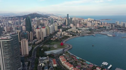 QINGDAO, CHINA – SEPTEMBER 2019: Drone flight of central business district and Fushansuo Bay in Qingdao, coastal city China