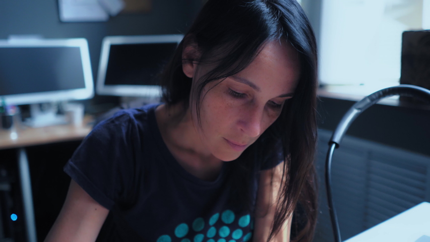 Busy Middle-Aged Woman Is Sitting In The Ofice At The Table And Writing Something. He Raises Her Head And Looks Up.