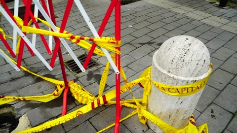 Rome - Italy, 10 February 2019: Marble transit bollard, broken off by a yellow tape of the municipal police of Rome in a street