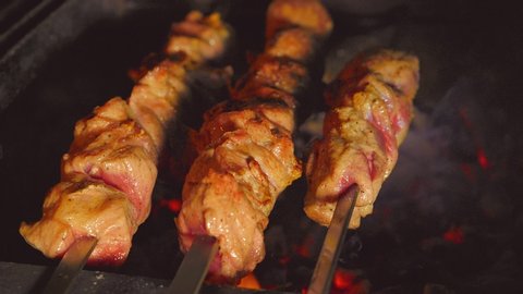 Meat on skewers on the grill. Tasty grilled food. Pork meat prepared on fire