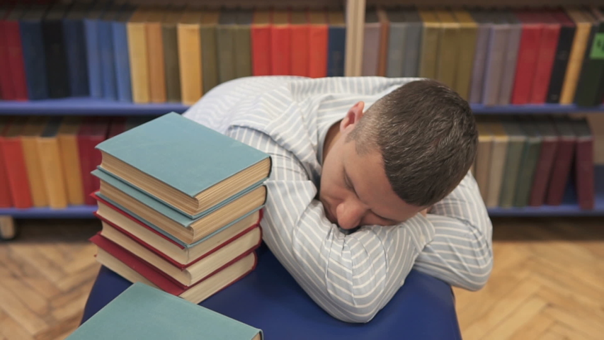 Young man sleeping in the library | Shutterstock HD Video #1041405634