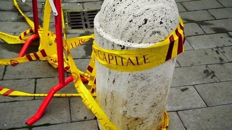 Rome - Italy, 10 February 2019: Marble transit bollard, broken off by a yellow tape of the municipal police of Rome in a street