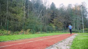 4k pan video of young fit man jogging in the morning outdoor on the running race track
