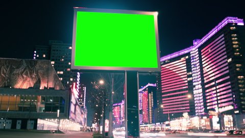 Modern billboard with green screen for advertising on a busy street with neon lights, blank billboard opposite the road, timelapse of traffic on busy highway, cyberpunk colors