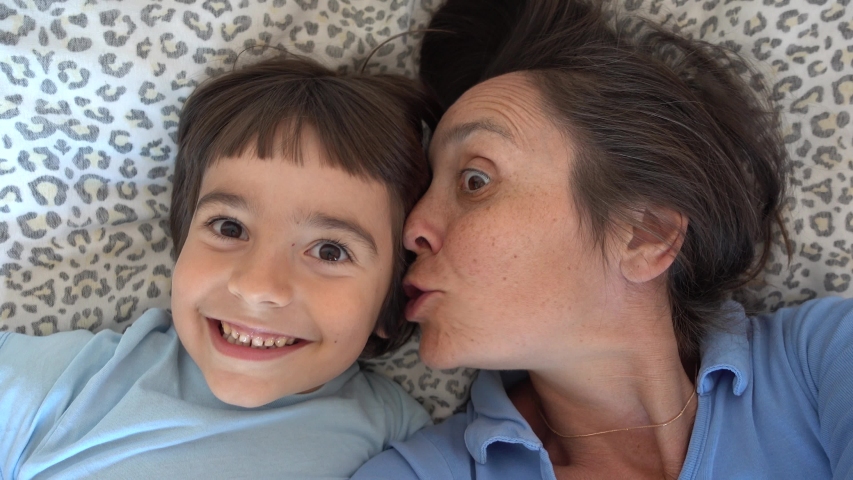 4K Selfie Mother whisters in ear of her son some secrets
