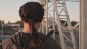 Back view of african american woman in sportswear going straight on the old bridge