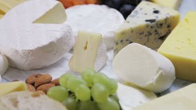 assorted different types of cheeses with fruits, nuts, dried fruits. Rotation video