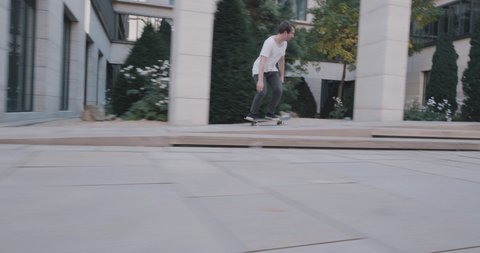 skateboarder jumping ollie trick down stairs in super slow motion at business buildings in 4k