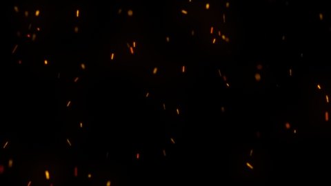 Fire sparks, dust particles  in front of a black background.