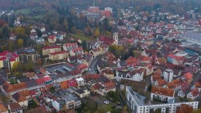 Aerial view around the city Emmendingen on a cloudy day in Autumn in Germany. Pan to the right and zoom out from the center of the city.
