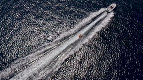 Aerial top down drone video of a boat towing ski tube in deep blue sea in Croatia on vacation in summer