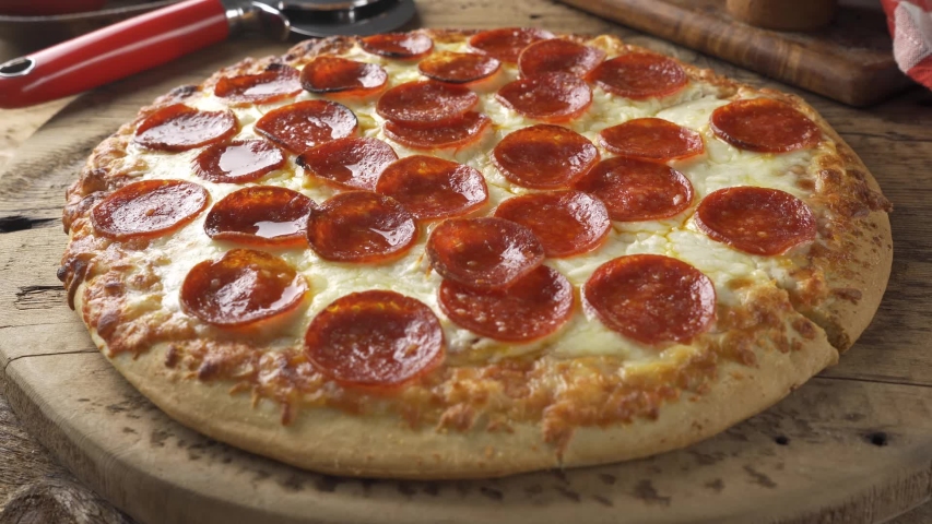 A slice of cheesy pepperoni pizza being served. Royalty-Free Stock Footage #1041487912