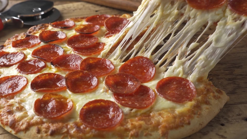 A slice of cheesy pepperoni pizza being served. | Shutterstock HD Video #1041487912