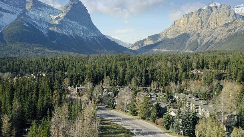 Aerial flying over the town of Canmore and Bow River near Banff. The town is surrounded by the Canadian Rocky Mountains. Alberta, Canada. 