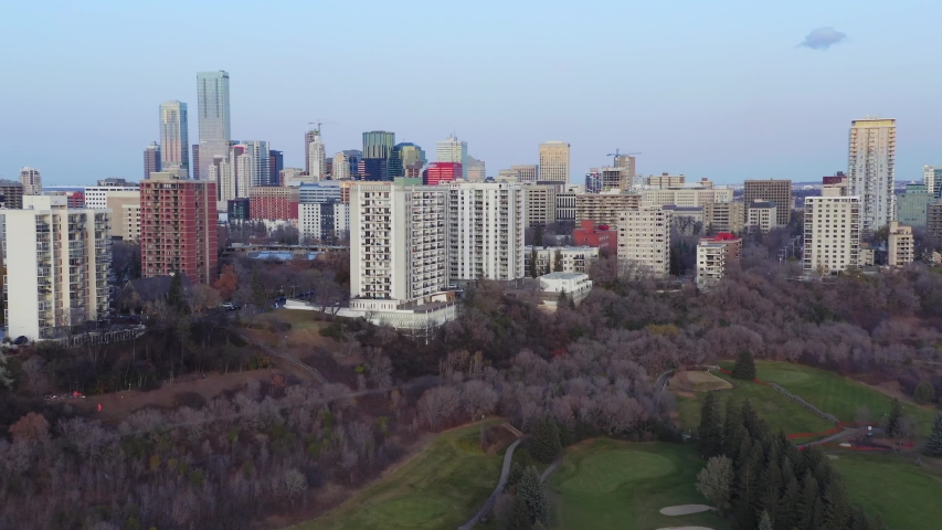 Aerial: Establishing shot of the Edmonton city skyline & apartment buildings at sunset. Edmonton, Alberta, Canada. 