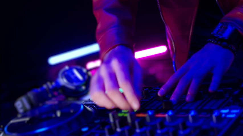 Close-Up of Dj Mixer Controller Desk in Night Club Disco Party. DJ Hands touching Buttons and Sliders Playing Electronic Music . Amazing Close Up of DJ Hands Mixing and Scratching Music on Vinyl Plate | Shutterstock HD Video #1041509965