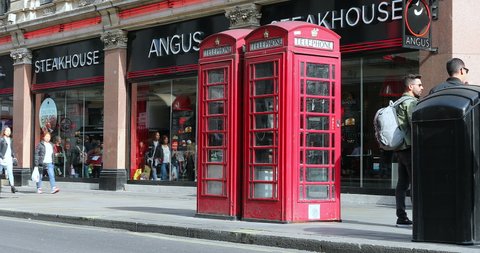 London, UK, May 28, 2019: Two Red British Telephone Boxes In Front Of Angus Steakhouse Restaurant On Coventry Street In The City Center Of London, United Kingdom, Europe - DCi 4K Resolution