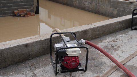 Footage of a flooded area and people pumping out water with a heavy duty high pressure aggregate pump machine from their houses and basements