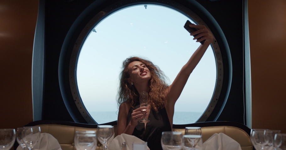 Bautiful girl in evening dress taking a selfie in the restaurant..