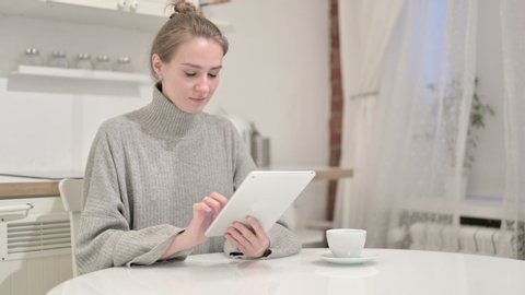 Hardworking Young Woman using Tablet at Home