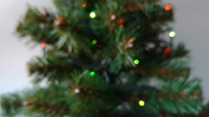 Blurred Christmas background with Christmas lights, seamless looped video: artificial Christmas tree decorated with garlands on a white background. | Shutterstock HD Video #1041523636
