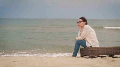 Calm women near the sea. A woman with a thoughtful expression sighs heavily near a sea.