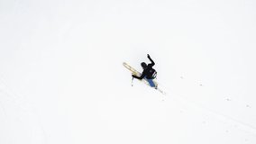 Aerial overhead, view of climber skier mountaineer man walking up snowy slope .Mountaineering ski activity. Skier walking up snowy land.Winter snow sport in alpine mountain outdoor.Back view.