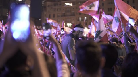 BEIRUT DOWNTOWN, LEBANON - NOV 22, 2019: Supporters of the Lebanese Revolution celebrate Lebanon's Independence Day and sing national anthems, 3 shots