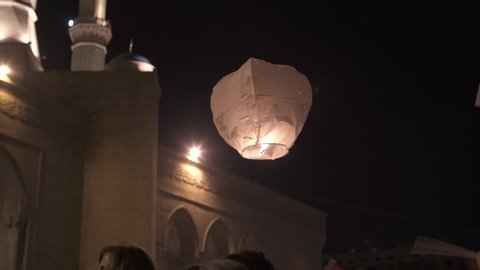 BEIRUT DOWNTOWN, LEBANON - NOV 22, 2019: Supporters of the Lebanese Revolution launching a sky lantern while celebrating Lebanon's Independence Day. Written on lantern "To my country Lebanon"