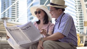 happy asian Senior couple tourists traveling Reading Newspaper together in urban city outdoors. old man Travellers lifestyle  . elderly woman vacation . ageing society concept.  - Powered by Shutterstock - Get 15% off with code: PIKWIZARD15
