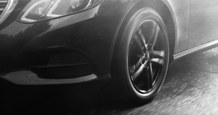 Reflecting everything around with its glossy surface, the premium car rides asphalt road where you can observe the suspension and how the tires perceive driving conditions. Black and white color 