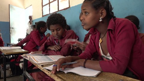 LALIBELA, ETHIOPIA – MARCH 2019: Girls read through textbooks in classroom of school in Lalibela, students learning mathematics in Ethiopia Africa