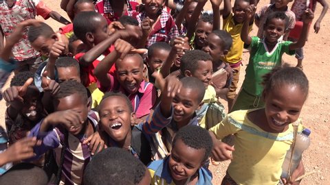 NORTH ETHIOPIA – MARCH 2019: Group of excited young school kids jump and dance in front of the camera lens in a small village in North Ethiopia, happiness and friendship in Africa