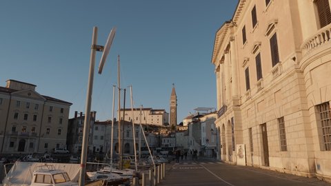 PIRAN,SLOVENIA ; APRIL 2019.
4k video. Camera moving shot. Central square with a monument and an ancient watch tower in Piran, Slovenia.