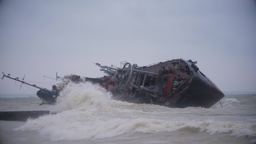 Telephoto shot of a tanker ship washed ashore during a sea storm. Oil spills Royalty-Free Stock Footage #1041544891