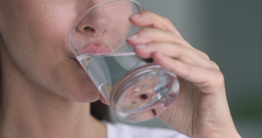 Healthy young lady holding glass drinking fresh transparent pure filtered mineral water, adult woman hydrating thirst keep diet nutrition weightloss health care natural balance concept, close up view | Shutterstock HD Video #1041547747