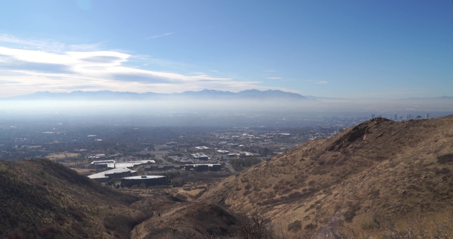 Slow pan to the right of the arid and dry hills of Salt Lake City with some city views behind